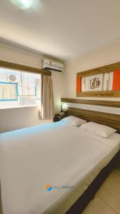 1 cama blanca grande en un dormitorio con ventana en Apartamentos 2 Quartos- Lacqua diRoma Caldas Novas, en Caldas Novas