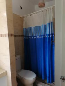 baño con aseo y cortina de ducha azul en HOTEL QUINTA DEL DESCANSO, en Cuautla Morelos