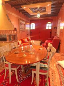 een eetkamer met een houten tafel en stoelen bij Riad Ennaciri in Safi