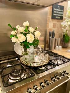 鲍特里Cosy Cottage Central Bawtry - 2 Bedroom - High End Furnishings的炉子上方的白色玫瑰花瓶