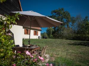 una mesa con sombrilla frente a una casa en Lac Bleu 25 en Lacapelle-Marival