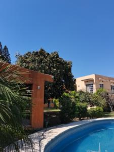 una piscina frente a un edificio con una casa en HOTEL QUINTA DEL DESCANSO, en Cuautla Morelos