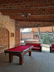 una mesa de billar en una habitación con una pared de ladrillo en HOTEL QUINTA DEL DESCANSO, en Cuautla Morelos