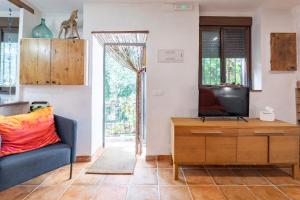 a living room with a tv and a blue couch at EL SECADERO in Alcudia de Veo