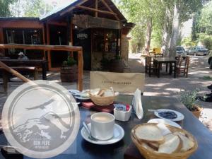 una mesa con un plato de comida y una taza de café en La margarita en Potrerillos