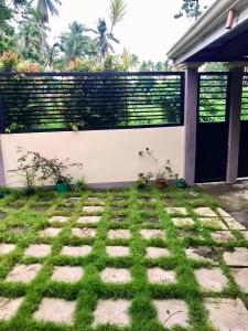 einen Hinterhof mit einem Zaun und Gras und einer Terrasse in der Unterkunft Pagadian City House Rental - Hidehouse in Pagadian