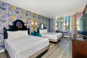 um quarto com duas camas e uma parede com flores em Hotel Fiona em São Francisco