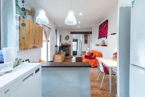 cocina abierta y sala de estar con sofá naranja en EL SECADERO, en Alcudia de Veo