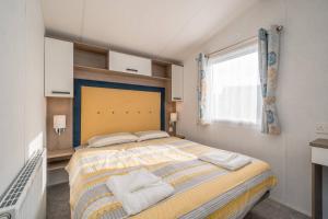 Un dormitorio con una cama grande y una ventana en Lisa Marie-Luxury Caravan-Seton Sands-8 Berth en Port Seton