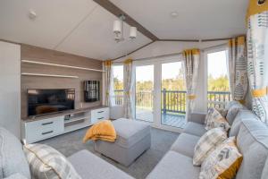 a living room with a couch and a tv at Lisa Marie-Luxury Caravan-Seton Sands-8 Berth in Port Seton