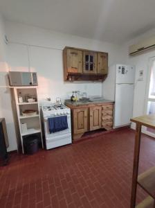 烏拉圭河畔康塞普西翁的住宿－Depto 9 de Julio，厨房配有白色炉灶和冰箱。