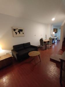 烏拉圭河畔康塞普西翁的住宿－Depto 9 de Julio，客厅配有黑色沙发和桌子