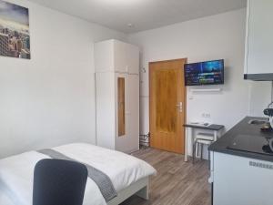 a small room with a bed and a kitchen at Studio Apartment mit Balkon 12 in Essen