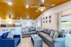 ein Wohnzimmer mit 2 Sofas und einem Deckenventilator in der Unterkunft Two J’s Paradise in Key Largo