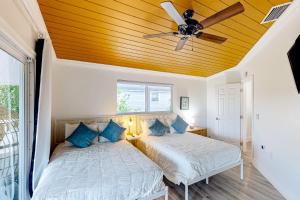 two beds in a room with a ceiling fan at Two J’s Paradise in Key Largo