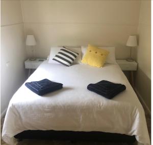 ein Schlafzimmer mit einem weißen Bett mit zwei Handtüchern darauf in der Unterkunft Iluka Beach House,Robe- stunning ocean views. in Robe