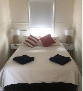 ein weißes Bett mit zwei Kissen darüber in der Unterkunft Iluka Beach House,Robe- stunning ocean views. in Robe