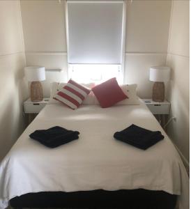 a white bed with two pillows on top of it at Iluka Beach House,Robe- stunning ocean views. in Robe
