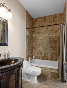 y baño con bañera, aseo y lavamanos. en Seaview Executive Home en Ladysmith