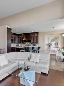 a living room with a white couch and a kitchen at Seaview Executive Home in Ladysmith