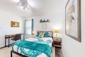 um quarto com uma cama e uma secretária em University Coastal Retreat em Pensacola