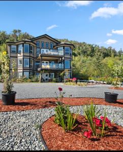a large house on a hill with a gravel driveway at Seaview Executive Home in Ladysmith