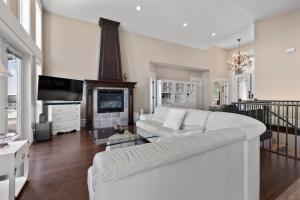 sala de estar con sofá blanco y chimenea en Seaview Executive Home en Ladysmith