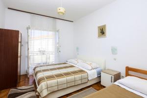 a bedroom with two beds and a window at Apartments by the sea Pirovac, Sibenik - 11824 in Pirovac