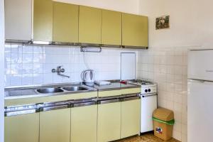 a kitchen with green cabinets and a sink and a refrigerator at Apartments by the sea Pirovac, Sibenik - 11824 in Pirovac +14 photos