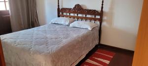 1 dormitorio con 1 cama grande con sábanas y almohadas blancas en Casa Maciel, en São Thomé das Letras