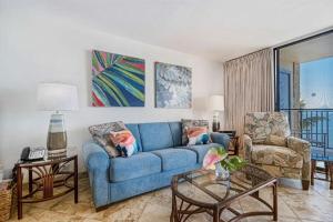 a living room with a blue couch and a chair at KIHEI BEACH, #406^ condo in Kihei