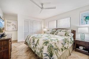 a bedroom with a bed and a fan and a window at KIHEI BEACH, #406^ condo in Kihei