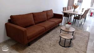 Sofá marrón en la sala de estar con mesa en FMS Logie, en Amberes