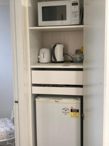 a microwave and a refrigerator in a kitchen at Midgee Cottage in Mudgee
