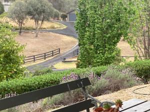 a park bench with a view of a road at Midgee Cottage in Mudgee