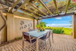 a table and chairs on a patio with a view of the ocean at WAILEA ELUA, #1305^ condo in Wailea