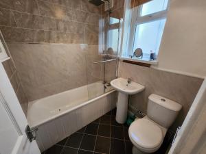 La salle de bains est pourvue de toilettes, d'un lavabo et d'une douche. dans l'établissement Greenvale Apartment, à Birmingham