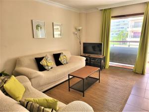 a living room with a couch and a tv at 2 bedrooms sea view apartament 100 meters from ocean in Los Cristianos