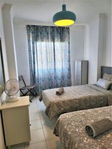 - une chambre avec deux lits et une lumière jaune dans l'établissement 2 bedrooms sea view apartament 100 meters from ocean, à Los Cristianos