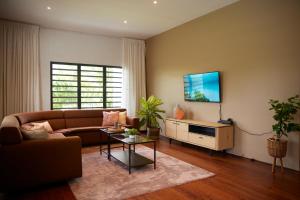 uma sala de estar com um sofá e uma mesa em Tropical Villa Rainville em Paramaribo