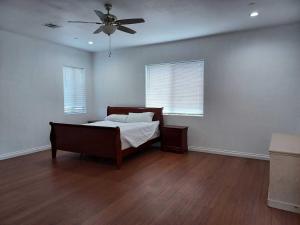 パームデールにあるAchieversのベッドと天井扇風機のある寝室