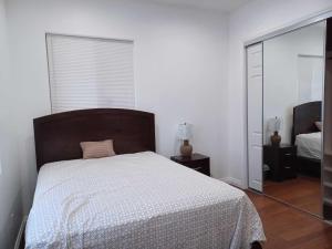 パームデールにあるAchieversのベッドと鏡のある白い寝室