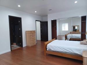 パームデールにあるAchieversのベッドとドレッサーと鏡のある寝室