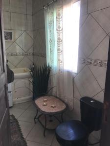 uma casa de banho com uma mesa, uma cadeira e uma banheira em Happy Guest House em Navegantes