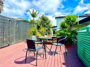 eine Terrasse mit einem Tisch und Stühlen auf einer Terrasse in der Unterkunft Modern Private 2 Bedroom Home-unit in Albany with Netflix in Auckland