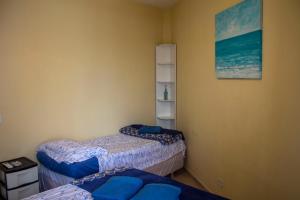 a room with two beds and a picture on the wall at Casa do Farol in Itapoa