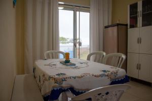 a dining room table with a table and chairs at Casa do Farol - Frente para a praia in Itapoa