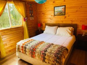 a bedroom with a bed in a log cabin at Cabañas Los Fabianes in Castro