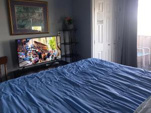 a bedroom with a bed and a flat screen tv at WaterfrontHome-RiverView, Windsor ,Canada in Windsor