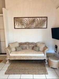 un sofá en una sala de estar con una foto en la pared en BUNGALOW F2 Atypical local style en Faaa